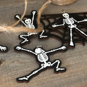 a lunging skeleton ornament lays on a rustic table