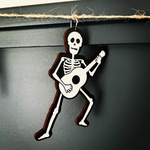 skeleton playing guitar hangs from a jute string
