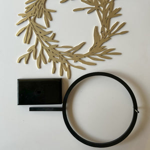 Flat lay of gold wreath, stand and wreath holder on a white background