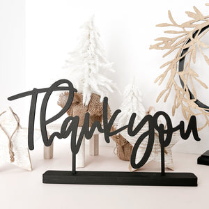 The Thank you Little Word Stand in black sitting in front of some white christmas decor
