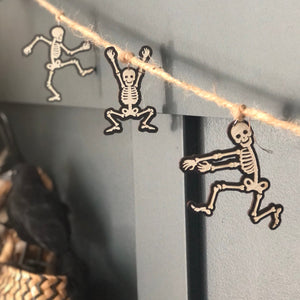 a section of garland of laser cut skeletons hanging from silver findings