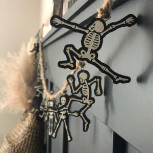skeletons hanging from jute twine striking their best pose