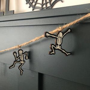 close up of two skeletons dancing while hanging from jute twine 